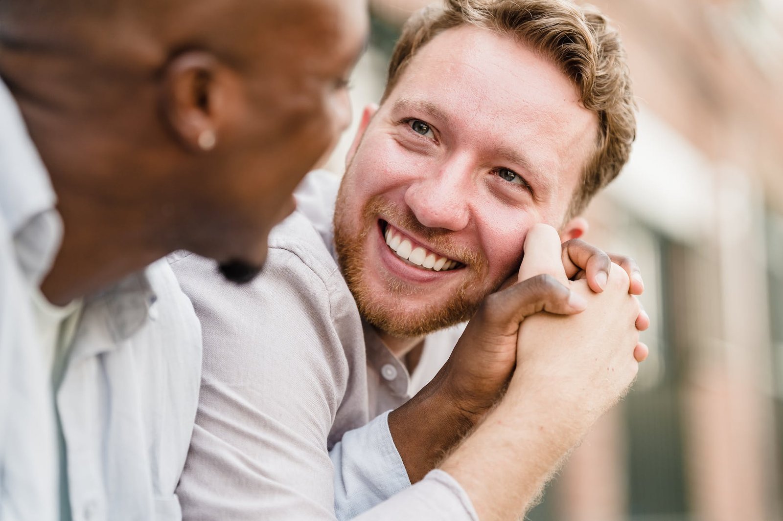 happy gay couple holding hands and looking each other in the eyes